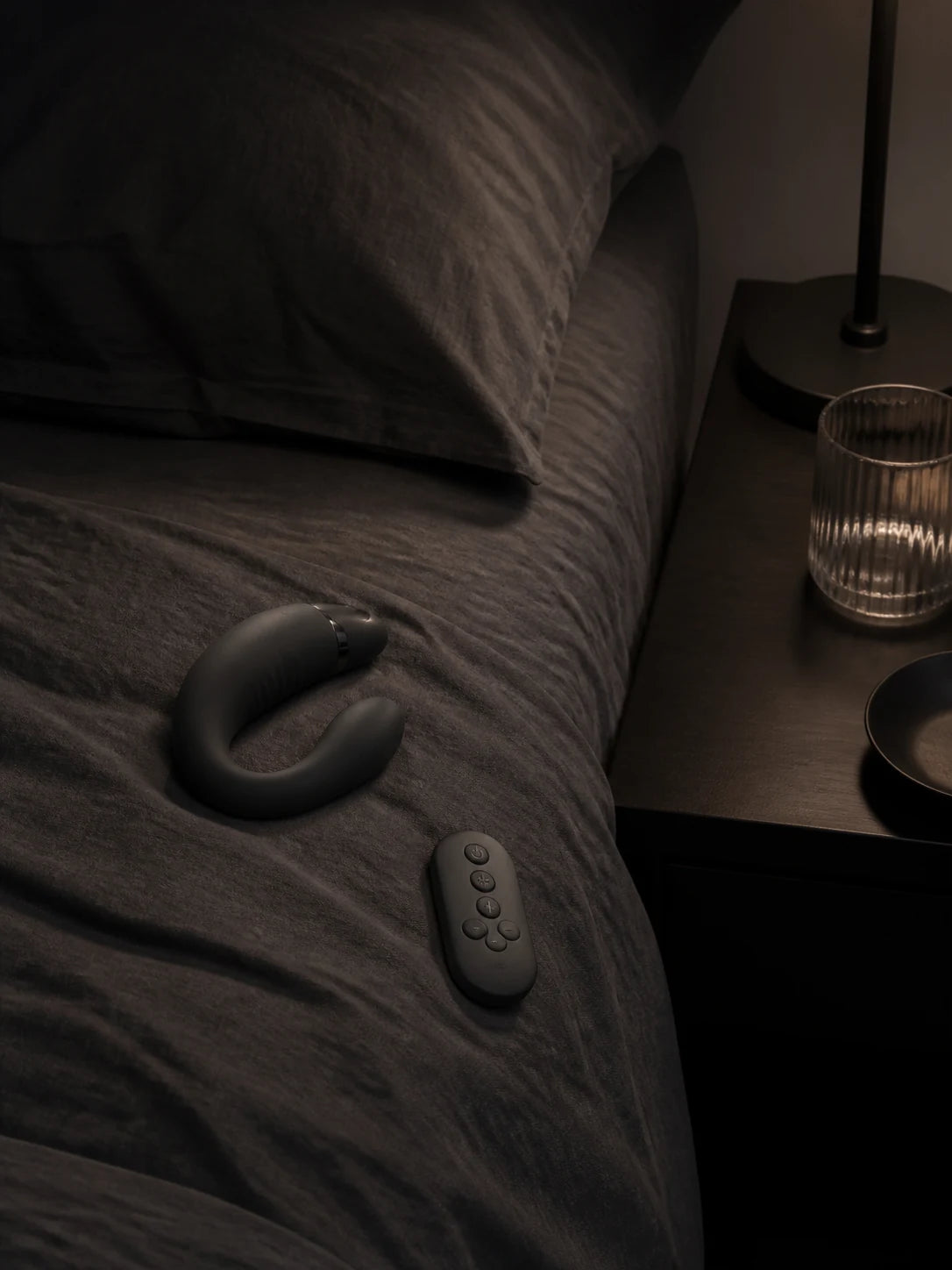 A generic primary device beside a dependent remote on a dark bed