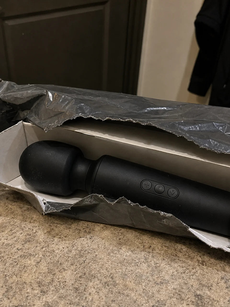 Ordinary black vibrator exposed in torn shipping packaging
